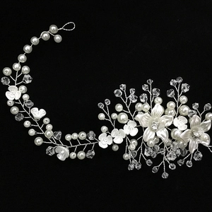 Detailed close-up of handmade bridal headband with white flowers, pearls and crystals