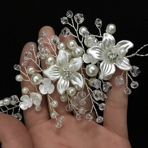 Close-up of handmade bridal headband with white flowers, pearls and crystals on silver wire