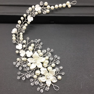 Detail of handmade bridal headband with white flowers, crystals and pearls on silver wire