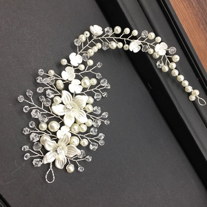 Macro view of bridal hair vine with silver wire, white flowers, and crystal pearls