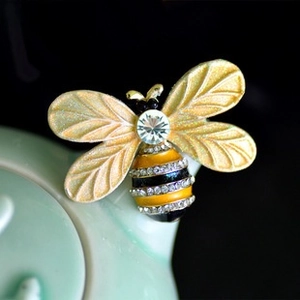 Detailed view of a golden bee brooch with sparkling rhinestones and black enamel accents