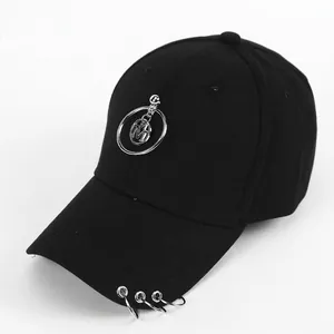 Detail of black cotton baseball cap with silver metal ring charms and M pendant logo