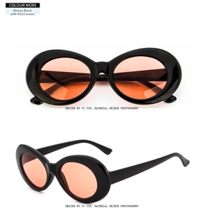Detailed macro view of retro oval sunglasses with shiny black frames and orange-red lenses