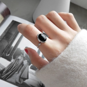 Macro shot of 925 sterling silver ring with oval black onyx stone on female hand