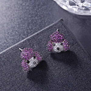 Macro shot of silver poodle stud earrings with purple and white cubic zirconia stones