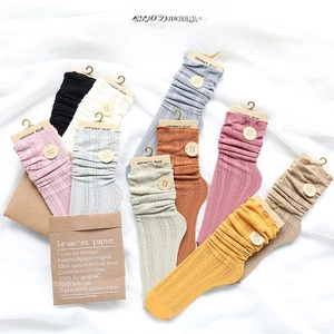 Flat lay of colorful knit slouch socks with eyelet lace trim and cable stitch patterns