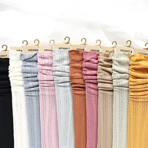 Close-up of multicolored hollow knit crew socks with delicate ruffle trim and cable texture