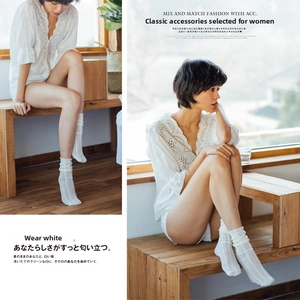 Close-up of white vertical hollow knit socks with ruffled edges and cable pattern detail
