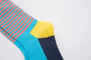 Close-up of colorful striped cotton socks with blue base, orange stripes and yellow heel