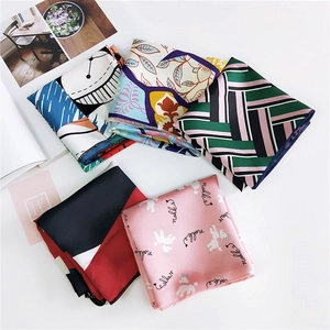 Detailed top view of assorted printed silk scarves with various patterns on white background