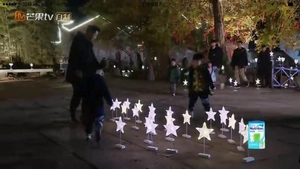 Close-up of decorative star-shaped LED fairy lights glowing in a night outdoor square scene