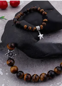 Macro detail of tiger eye stone beads with star charms and hexagram spacers on a bracelet