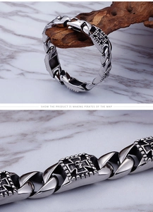 Macro detail of men's stainless steel bracelet with skull and cross embossed links