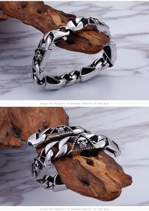 Detail of masculine stainless steel bracelet with skull relief on cuban link chain