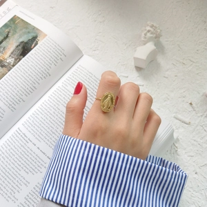 Macro detail of a vintage S925 silver gold-plated Mary medal ring worn on a finger