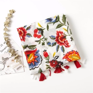 Detail of floral linen shawl with ethnic prints, tassels and artistic accessories