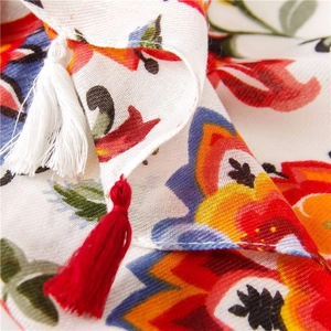Detailed macro view of colorful floral prints and two-tone tassels on a cotton linen shawl