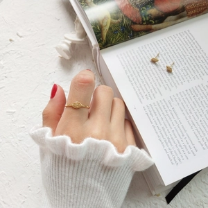 Detailed view of gold Evil Eye jewelry set featuring rings and stud earrings on a book
