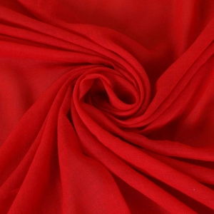 Macro shot of vibrant red lace tassel scarf fabric showing weave texture and softness