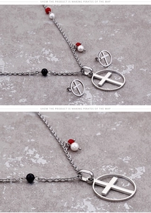 Detail of silver necklace and earrings set with colored beads and hollow cross charms
