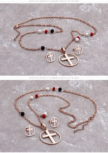 Detail of rose gold necklace and earrings set with cross pendant and colorful beads
