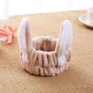 Close-up of soft beige plush headband featuring cute white rabbit ear design details