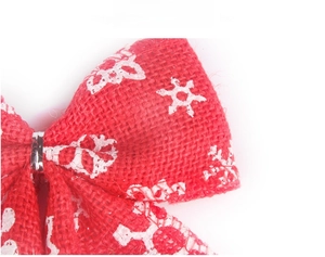 Close-up of red linen Christmas bow with white snowflake pattern and silver metal ring