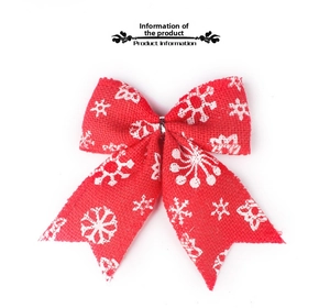 Close-up of red burlap Christmas bow with white snowflake patterns and texture details
