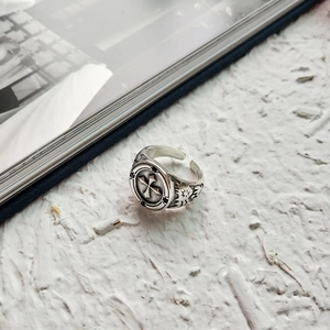 Macro detail of retro S925 sterling silver ring with cross relief and oxidized finish