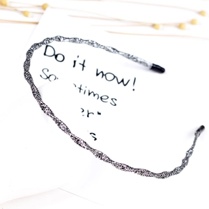 Detail shot of a slim silver woven texture headband with protective black end caps
