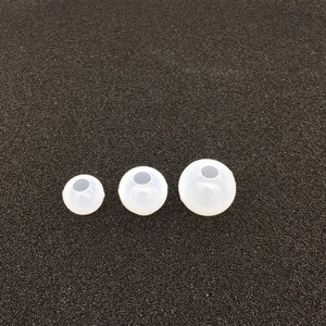 Detailed view of three sizes of white translucent silicone replacement earbud tips
