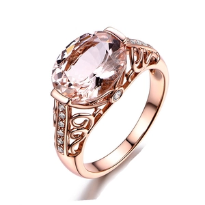 Close-up of 18K rose gold ring with large oval pink gemstone and filigree details