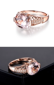 Detail of rose gold ring with pink round-cut gemstone and hollow carved band design
