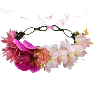 Detailed view of floral hair wreath with purple and white fabric flowers and pink ribbon