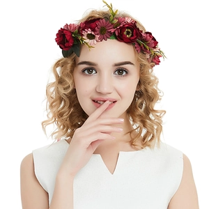 Close-up of wine red velvet rose hair clips with green leaves worn by a model