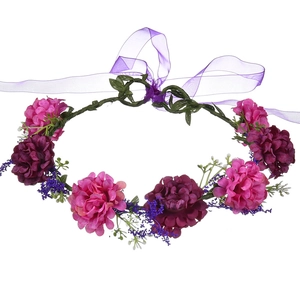 Detailed close-up of purple velvet rose hair wreath with green leaves and ribbon tie