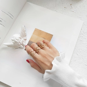 Close-up of gold geometric rings set with moon and star motifs on a vintage book