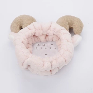 Detail view of soft pink coral fleece headband with brown goat horns and white ears