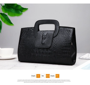 Close-up of black faux crocodile skin handbag with 3D crocodile head detail and hollow handle