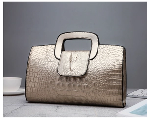 Macro view of champagne gold faux crocodile texture with 3D animal head relief detail