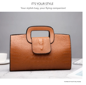 Detailed view of brown crocodile-embossed handbag featuring a unique animal head relief
