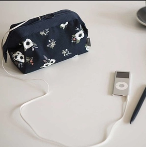 Navy blue floral flamingo travel makeup bag with zipper on white table lifestyle view
