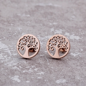 Rose gold hollow tree of life earrings set on textured grey surface with metallic luster