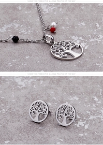 Detail of silver tree of life necklace and earrings set with red and black beads