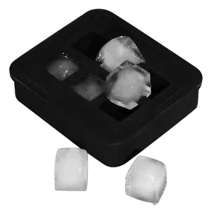 Detail view of a black silicone square ice cube tray with clear ice blocks on top