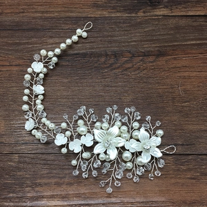 Detail of silver bridal headband with white ceramic flowers, pearls and crystals