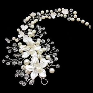 Detail of bridal hairband with white flowers, crystal rhinestones and pearls on black background