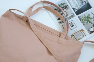 Detail of dusty pink canvas tote showing durable straps and premium fabric texture