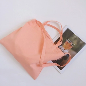 Detail of light peach canvas tote bag with sturdy handles and wide opening design