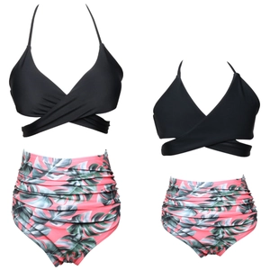 Flat lay of matching mother and daughter bikini sets with palm leaf print high waist bottoms